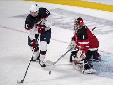 USA's Alex Tuch tries to deflect a shot past Canada's goaltender Eric Comrie during first period preliminary round hockey action at the IIHF World Junior Championship, Wednesday, December 31, 2014 in Montreal.