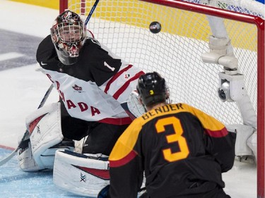 Team Canada goaltender Eric Comrie makes a save off Team Germany's Tim Bender during first period preliminary round hockey action at the IIHF World Junior Championship, Saturday, December 27, 2014 in Montreal.