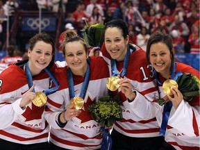 Left to right: Catherine Ward, Marie-Philip Poulin, Caroline Ouellette and Charline Labonté of Team Canada celebrate with their gold medals at the 2010 Vancouver Olympics.