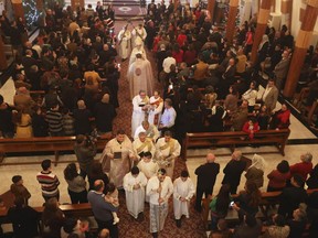 Iraqi Christians attend a Christmas Eve mass at Our Lady of Salvation in Baghdad, Iraq, Wednesday, Dec. 24, 2014. Iraqi Christians gathered for Christmas Eve services amid tight security.