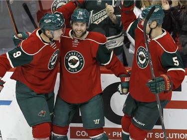 Minnesota Wild left wing Jason Zucker, centre, celebrates with teammates Mikko Koivu (9), of Finland, and Christian Folin (5) after Zucker's goal against the Montreal Canadiens during the first period of an NHL hockey game in St. Paul, Minn., Wednesday, Dec. 3, 2014.