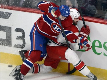 Carolina Hurricanes defenceman Jay Harrison (44) is checked into the boards by Montreal Canadiens left wing Jiri Sekac (26) during second period National Hockey League action Tuesday, December 16, 2014 in Montreal.