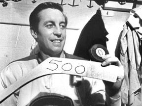 Jean Béliveau poses with the puck and stick he used to score his 500th career goal with the Canadiens in 1971.