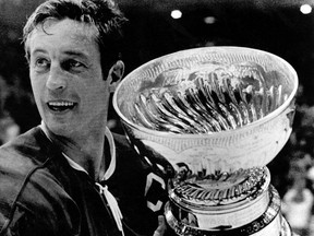 FILE - In this May 19, 1971, file photo, Montreal Canadiens team captain Jean Beliveau holds the Stanley Cup in Chicago following the Canadiens 3-2 victory over the Chicago Blackhawks. Beliveau died Tuesday, Dec. 2, 2014. He was 83. The team confirmed the death of the Hall of Fame center and one of the most beloved players in Canadiens history. (AP Photo/File)