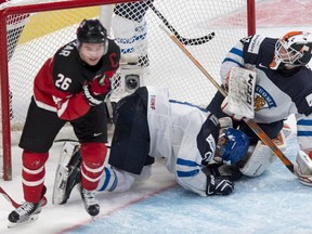 Team Finland goaltender Juuse Saros and Julius Honka lie on the ice as Team Canada's Curtis Lazar celebrates his goal during third period preliminary round hockey action at the IIHF World Junior Championship Monday, December 29, 2014 in Montreal.