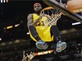 Cleveland Cavaliers forward LeBron James  hangs onto the basket after a dunk during game against the Miami Heat on Dec. 25, 2014.