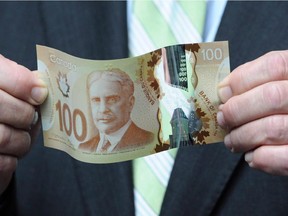 The new polymer-based $100 billFinance Minister Jim Flaherty holds a new polymer-based $100 bill as he takes part in the unveiling of the new polymer bank notes in $50 and $100 denominations at the Bank of Canada in Ottawa on Monday, June 20, 2011. The penny may be history, but some Canadians suspect the Bank of Canada has been circulating a new scent along with its plastic bank notes. Dozens of people who contacted the bank in the months after the polymer notes first appeared asked about a secret scratch-and-sniff patch that apparently smells like maple syrup.THE CANADIAN PRESS/Sean Kilpatrick ORG XMIT: CPT102)  Possible art for Kirsten Smith (Postmedia News) 0912-nhs-highlights & 0912-nhs-income-box: