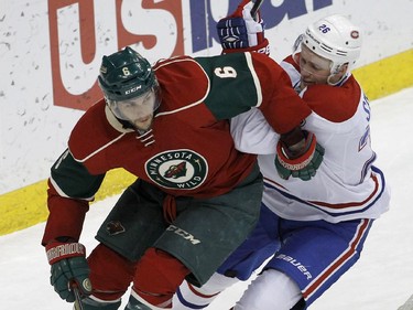 Minnesota Wild defenceman Marco Scandella, left, controls the puck in front of Montreal Canadiens left wing Jiri Sekac, right, of the Czech Republic, during the third period of an NHL hockey game in St. Paul, Minn., Wednesday, Dec. 3, 2014. The Wild won 2-1.