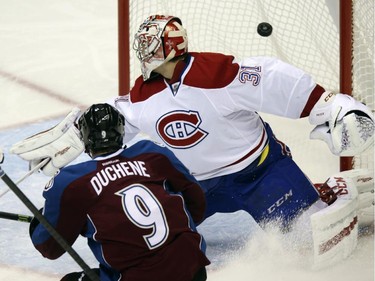 Colorado Avalanche centre Matt Duchene, front, looks on as his shot bangs between the pipes behind Montreal Canadiens goalie Carey Price in the second period of an NHL hockey game in Denver on Monday, Dec. 1, 2014. The puck did not go into the net on the play.