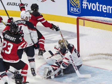 Canada's Max Domi scores past USA goaltender Thatcher Demko during second period preliminary round hockey action at the IIHF World Junior Championship, Wednesday, December 31, 2014 in Montreal. Canada's Sam Reinhart and USA's Will Butcher look on.