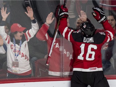 Canada's Max Domi goes to the fans to celebrate his goal past USA goaltender Thatcher Demko during second period preliminary round hockey action at the IIHF World Junior Championship Wednesday, December 31, 2014 in Montreal.