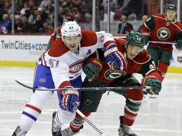 Montreal Canadiens left wing Max Pacioretty (67) and Minnesota Wild defenceman Jared Spurgeon (46) battle for the puck during the second period of an NHL hockey game in St. Paul, Minn., Wednesday, Dec. 3, 2014.