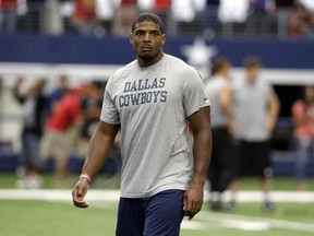 Former Dallas Cowboy Michael Sam walks on the field before NFL game in Arlington, Tex., on Sept. 7, 2014. Sam has signed a two-year deal with the Montreal Alouettes.