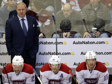 Montreal Canadiens head coch Michel Therrien, back, looks on against the Colorado Avalanche in the second period of an NHL hockey game in Denver on Monday, Dec. 1, 2014.