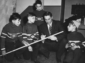 Jean Béliveau signs a stick for a group of boys at the Richelieu Club's Christmas party at Montreal's Botanical Gardens in 1956. Béliveau was a surprise guest at the event.