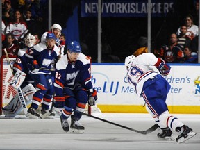 Andrei Markov scores a second period goal as Anders Lee of the Islanders defends at Nassau Veterans Memorial Coliseum Tuesday in Uniondale, N.Y. This was Markov's 800th game.