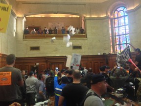 Montreal firefighters and municipal employees protesting against pension reforms stormed city hall on Aug. 18, 2014, tossing papers throughout the building and in council chambers minutes before city council was scheduled to begin its evening session. (Rene Bruemmer / THE GAZETTE)