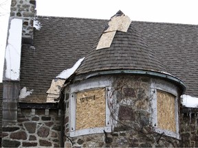 Boarded-up windows and damage to the roof in the aftermath of a fire at a mansion on Senneville Rd.