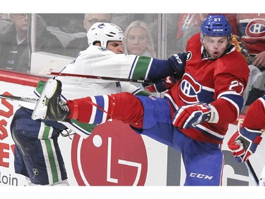 Montreal Canadiens Alex Galchenyuk, right, is knocked off balance by Vancouver Canucks Kevin Bieksa during second peiod of National Hockey League game in Montreal Tuesday December 09, 2014.