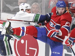 The Canadiens' Alex Galchenyuk gets knocked off balance by Vancouver Canucks defenceman Kevin Bieksa during game at the Bell Centre on Dec. 9, 2014.