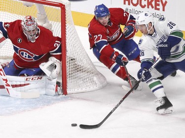 Montreal Canadiens Carey Price, left, and Alex Galchenyuk defend their goal as  Vancouver Canucks Jannik Hansen skates out from behind the net during National Hockey League game in Montreal Tuesday December 09, 2014.