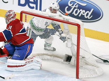 Montreal Canadiens goalie Carey Price slides across his crease as Vancouver Canucks Brad Richardson carries the puck behind the net during National Hockey League game in Montreal Tuesday December 09, 2014.
