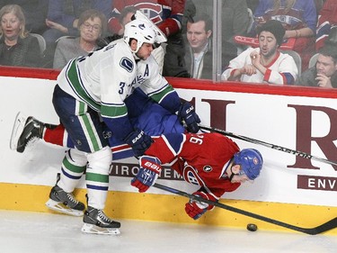 Montreal Canadiens Jiri Sekac is checked by Vancouver Canucks Kevin Bieksa during third period of National Hockey League game in Montreal Tuesday December 09, 2014.