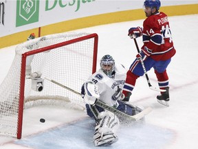 Montreal Canadiens Tomas Plekanec scores the winning goal past Vancouver Canucks goalie Ryan Miller during third period of National Hockey League game in Montreal Tuesday December 09, 2014.