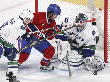 Vancouver Canucks Ryan Stanto, left, lifts Montreal Canadiens David Desharnais's stick preventing him from shooting the puck in front of goalie Ryan Miller during second period of National Hockey League game in Montreal Tuesday December 09, 2014.