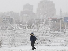 Arron Vuong walks south on Peel Street during a snow squall in Montreal, Wednesday December 10, 2014.