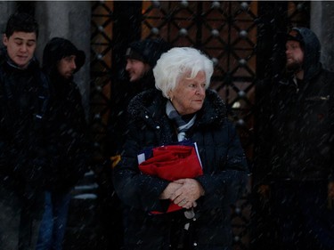 Élise Béliveau wipes a tear from her eye as she takes a moment alone at the front of the hearse after the funeral for Montreal Canadiens legend Jean Béliveau in Montreal on Wednesday December 10, 2014.