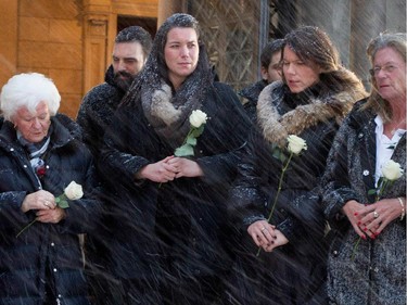 Élise Béliveau is surrounded by her family as she leaves the funeral for Montreal Canadiens legend Jean Béliveau in Montreal on Wednesday December 10, 2014.  Granddaughters Mylène and Magalie, left to right, and daughter Hélène are seen.