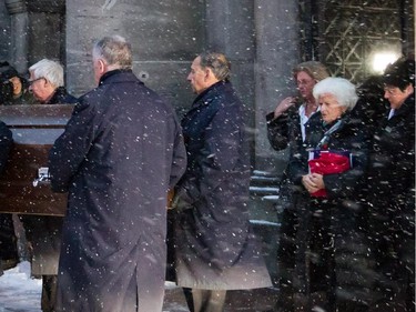 Pallbearers bring out the casket of Montreal Canadiens great Jean Béliveau as they are followed by his widow Élise Béliveau, second from right, and daughter Hélène, third from left, at the end of the funeral for the former Canadiens Captain at the Mary Queen of the World Cathedral in Montreal on Wednesday, December 10, 2014.