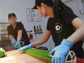 A graduate of John Molson, Lin Geng , left, has opened La Confiserie CandyLabs , what he calls Canada's first hand-made artisan candy shop, in Montreal.With the help of his girlfriend, May He, right, they stretch the candy paste which is very hot in order to reduce its size and width.