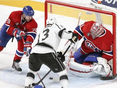 Montreal Canadiens Andrei Markov, left, helps goalie Carey Price as Los Angeles Kings Lyle Clifford tries to get his stick on the puck during third period of National Hockey League game in Montreal Friday December 12, 2014.