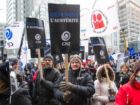 People gather to protest against austerity measures outside the Sheraton hotel in Montreal where Quebec Treasury board president Martin Coiteux was speaking on Friday, December 12, 2014.