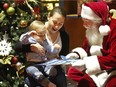 Carole Girard and 19-month-old Erwan meet Santa at his village in Montreal's Complexe Desjardins.