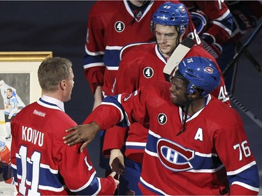 Former Montreal Canadiens captain Saku Koivu gets a pat on the shoulder from P.K. Subban during ceremony prior to National Hockey League game between the Habs and the Anaheim Ducks in Montreal Thursday December 18, 2014.