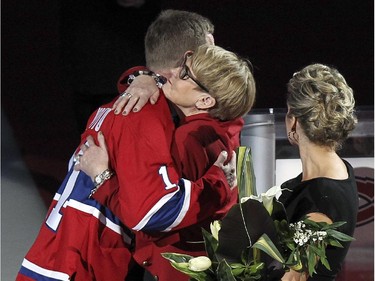 Former Montreal Canadiens captain Saku Koivu gets a hug from his mother Tuile as his wife Hanna watches during ceremony prior to National Hockey League game between the Habs and the Anaheim Ducks in Montreal Thursday December 18, 2014.