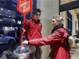 Student Raphaël Cossette greets Jessica Lonardi as she puts money in the  the Salvation Army pot at the Cinq Saisons grocery store in Westmount, in Montreal Thursday December 18, 2014. (John Mahoney / MONTREAL GAZETTE)
