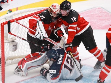 MONTREAL, QUE.: DECEMBER 26, 2014 -- Goalie Zach Fucale and Max Domi of Team Canada try to clear Dominik Rehak of Team Slovakia  from in front of the net in the second period of a preliminary round hockey game at the IIHF World Junior Championship at the Bell Centre in Montreal, on Friday, December 26, 2014. (John Kenney / MONTREAL GAZETTE)