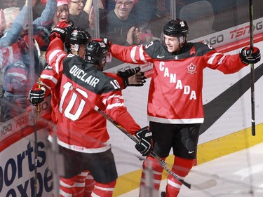 MONTREAL, QUE.: DECEMBER 26, 2014 -- Robby Fabbri (left, partially blocked) of Team Canada celebrates the first of his two goals against Team Slovakia in the first period  with teammates Anthony Duclair and Sam Reinhart during a preliminary round hockey game at the IIHF World Junior Championship at the Bell Centre in Montreal, on Friday, December 26, 2014. (John Kenney / MONTREAL GAZETTE)