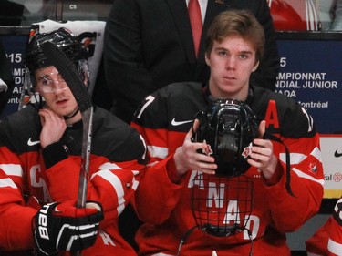 MONTREAL, QUE.: DECEMBER 26, 2014 -- Top-rated player Connor McDavid (right) of Team Canada prepares to put on his helmet for the start of a game against Team Slovakia in the preliminary round hockey game at the IIHF World Junior Championship at the Bell Centre in Montreal, on Friday, December 26, 2014. (John Kenney / MONTREAL GAZETTE)