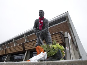 A bouquet of flowers and a scarf placed by fans at the statue honouring Canadiens captain Jean Beliveau, outside the Colisée Jean Béliveau in Longueuil south of Montreal, Dec. 3, 2014.