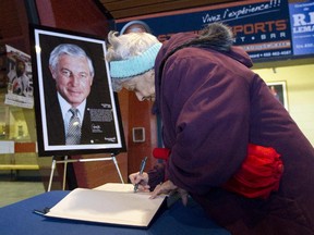 Mariette Vervais signs a book of condolence honouring Canadiens legend Jean Béliveau at the Colisée Jean Béliveau in Longueuil, south of Montreal, on Dec. 3, 2014, the day after Béliveau died at age 83.