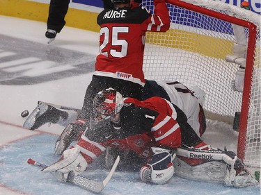 Darnell Nurse of Team Canada pushes Alex Tuch of Team USA inside net of Canada's Eric Comrie, during first period preliminary round hockey action at the IIHF World Junior Championship in Montreal on Wednesday December 31, 2014.