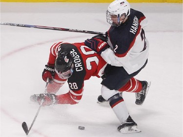 Noah Haninfin, right, of Team USA battles with Team Canada's Lawson Crouse, during second period preliminary round hockey action at the IIHF World Junior Championship in Montreal on Wednesday December 31, 2014.
