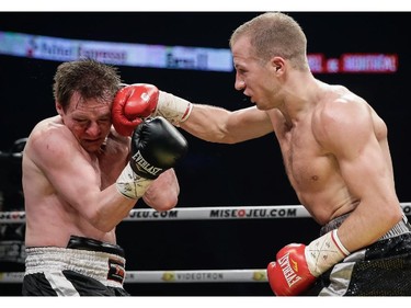 David Théroux of Sorel-Tracy, right exchanges punches with Maurice Gojko of Poland, left, during their super lightweight boxing match at the Bell Centre in Montreal on Saturday, December 6, 2014.