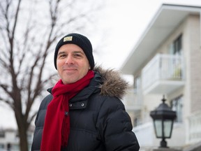 Playwright Steve Galluccio in St-Léonard, with a white-brick duplex in the background – like the one where his play, The St. Leonard Chronicles, is set.