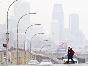 A pedestrian crosses the street during a smoggy Montreal day in February 2012.